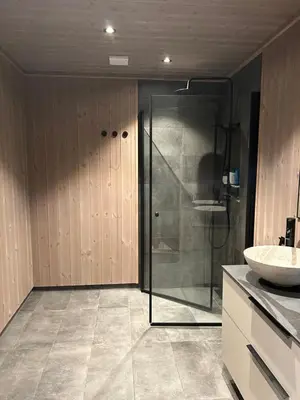a bathroom with a glass shower and a sink at Eksklusiv hytte Musdalsseter in Mo