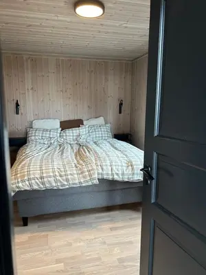 a bedroom with a bed in a room with wooden walls at Eksklusiv hytte Musdalsseter in Mo