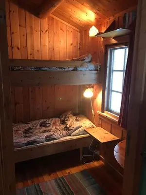 a room with a bed and a desk in a cabin at Simple family cabin at Haugen, Femundsmarka in Elga