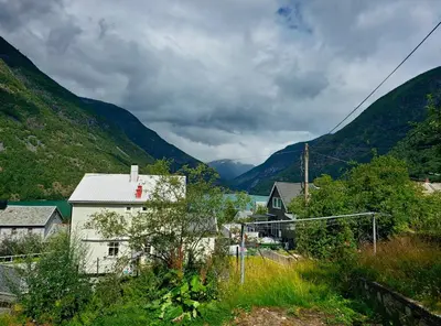 a village in a valley with mountains in the background at Charming 2-bedroom loft by UNESCO site Jotunheimen and Vettifossen! in Årdalstangen