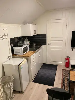 a kitchen with white cabinets and a white microwave at Charming 2-bedroom loft by UNESCO site Jotunheimen and Vettifossen! in Årdalstangen