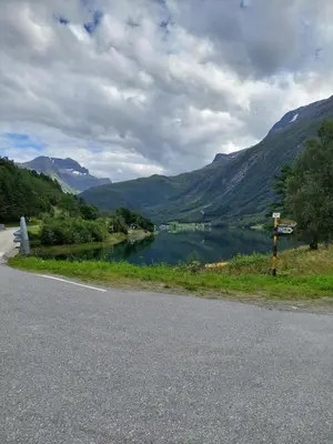 a road with a view of a lake and mountains at timber cabin Eresfjord med båt til leie in Øverås
