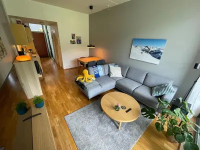 a living room with a couch and a table at Cozy 1-bedroom in quiet Ilsvika in Trondheim