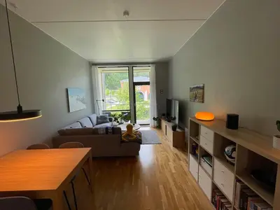a living room with a couch and a table at Cozy 1-bedroom in quiet Ilsvika in Trondheim