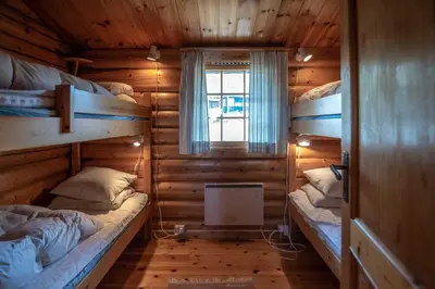 a room with two bunk beds in a log cabin at Trysilfjellet Sør 204 in Trysil
