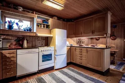 a kitchen with white appliances and wooden cabinets at Trysilfjellet Nord 607 in Trysil