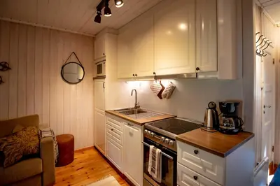 a kitchen with white cabinets and a sink and a stove at Trysilfjellet Nord 1071B in Trysil