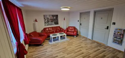 a living room with two red chairs and a table at Storgata 36B in Lillehammer