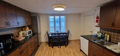 a kitchen with a table and chairs in a room at Storgata 36B in Lillehammer
