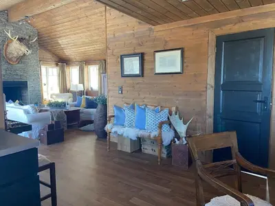 a living room with blue pillows on a wall at Wonderful Ski-In, ski-out Cabin at Kvitfjell in Strande