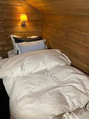 a large white bed in a room with wooden walls at Wonderful Ski-In, ski-out Cabin at Kvitfjell in Strande