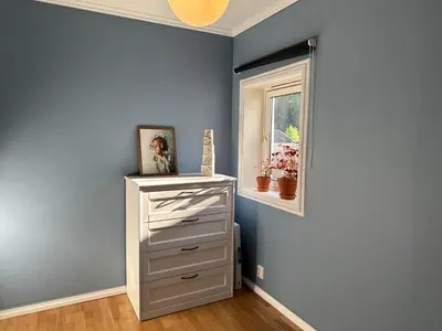 a blue room with a dresser and a window at Granåsen ski-VM in Trondheim