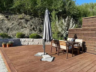 a patio with an umbrella and a table and chairs at Granåsen ski-VM in Trondheim