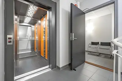a corridor with doors in a room with chairs at Modern and chic city apartment - Bergen City in Bergen