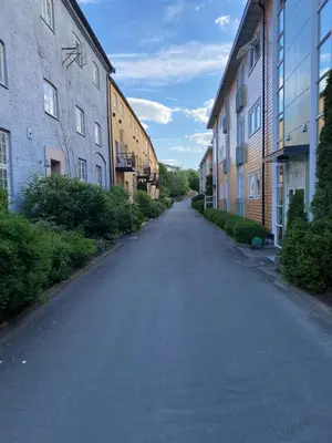 an empty road between two buildings on a street at Beautiful and central apartment for rent during Ski WC 2025 in Trondheim