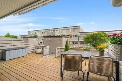 a balcony with a wooden deck with chairs and a table at Spacious and Peaceful Home with a Private Gym in Trondheim