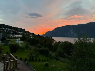 a sunset over a body of water with mountains at FjordView in Stranda