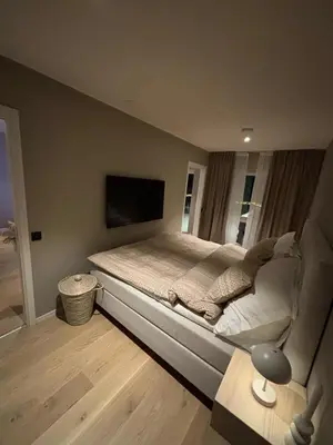 a bedroom with a large bed with a flat screen tv at Modern Appartement - Ski World Cup 2025 in Trondheim