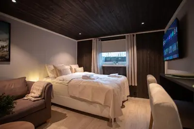 a bedroom with a bed and a flat screen tv at Studio Plassen in Sogndal