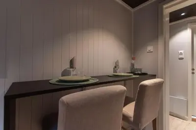 a kitchen with a table with two plates and chairs at Studio Plassen in Sogndal