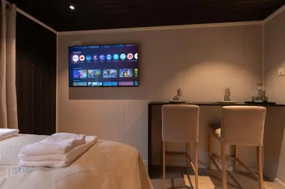 a bedroom with a bed and a tv on the wall at Studio Plassen in Sogndal