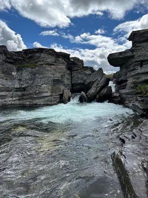 a body of water next to some rocks at Koselig hytte med uthus på vakre Dovrefjell in Dovre