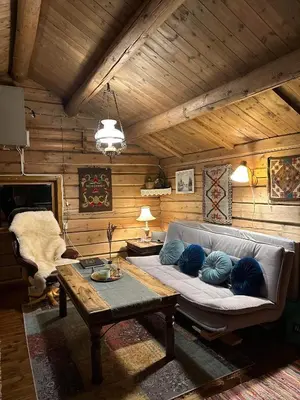 a living room with a couch and a table at Koselig hytte med uthus på vakre Dovrefjell in Dovre