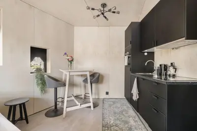 a small kitchen with a table and two stools at Architectural Studio I Private Balcony in Bergen