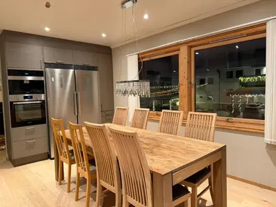 a kitchen with a wooden table and chairs and a refrigerator at World championship ski 2025-Cozy house for rent in Trondheim