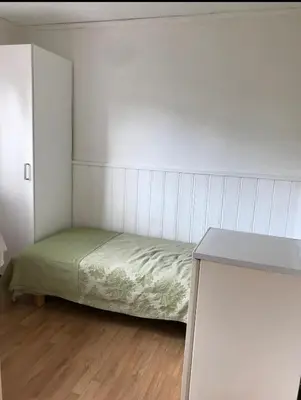 a small bedroom with a bed and a table at World championship ski 2025-Cozy house for rent in Trondheim