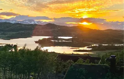 a sunset over a body of water with mountains at Stunninng Home In Rauland With Sauna in Rauland