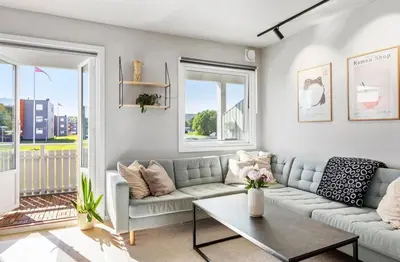 a living room with a couch and a table at Lys og koselig leilighet in Trondheim