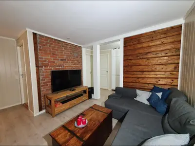 a living room with a couch and a brick wall at Koselig leilighet på Møllenberg in Trondheim