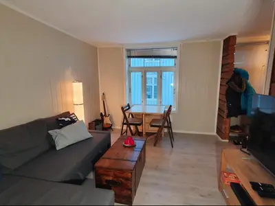 a living room with a couch and a table at Koselig leilighet på Møllenberg in Trondheim