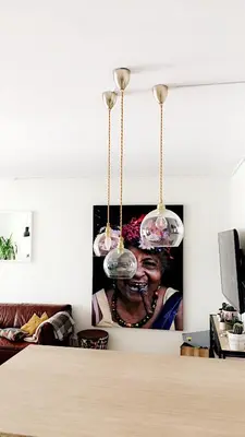 a living room with a picture of a woman under two lights at Townhouse in quiet and central area with free parking in Trondheim