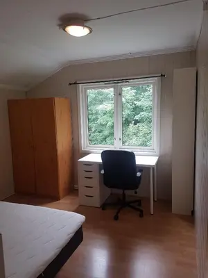 a bedroom with a desk and a chair in front of a window at 4 and 6 bedroom apartments Ski WC in Trondheim