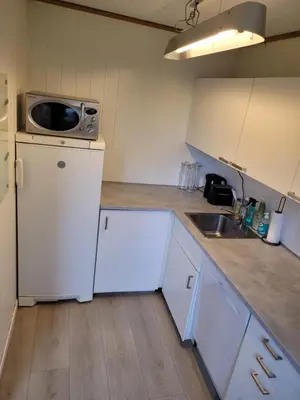 a kitchen with a white refrigerator and a microwave at 4 and 6 bedroom apartments Ski WC in Trondheim