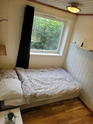 a small bedroom with a bed and a window at 4 and 6 bedroom apartments Ski WC in Trondheim