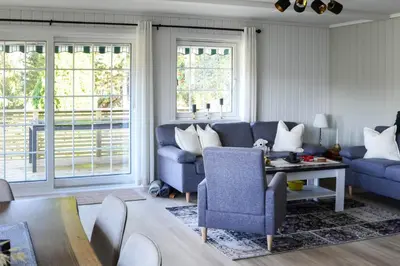 a living room with a couch and chairs and windows at ThePearl in Sel
