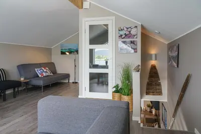 a living room with a couch and a mirror at Eget hus i sjøkanten ved fjorden in Langevåg