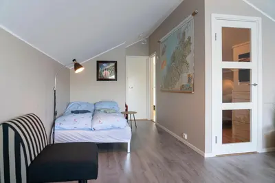 a bedroom with a bed and a chair in it at Eget hus i sjøkanten ved fjorden in Langevåg