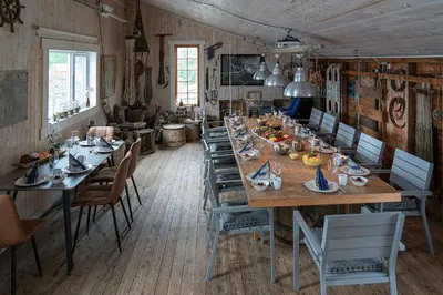 a dining room with a long table and chairs at Eget hus i sjøkanten ved fjorden in Langevåg