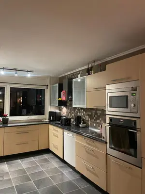 a large kitchen with stainless steel appliances and windows at 2 etasjers leilighet in Trondheim