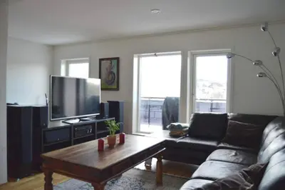 a living room with a couch and a coffee table at Modern 3-story house by the sea & public transport in Trondheim