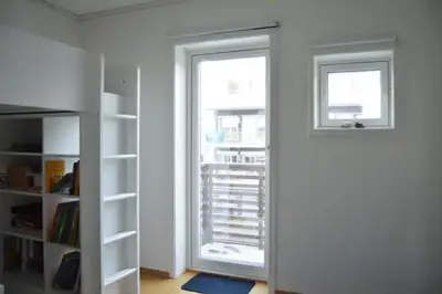 a room with a door and a window and a book shelf at Modern 3-story house by the sea & public transport in Trondheim