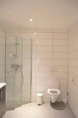 a bathroom with a shower and a toilet in it at Modern 3-story house by the sea & public transport in Trondheim