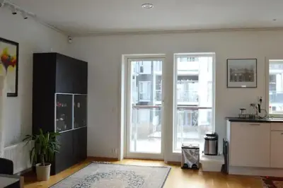 a living room with a kitchen and a large sliding glass door at Modern 3-story house by the sea & public transport in Trondheim