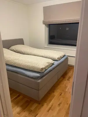 a bedroom with a bed and a large window at Apartment Sjusjøen in Sjusjøen
