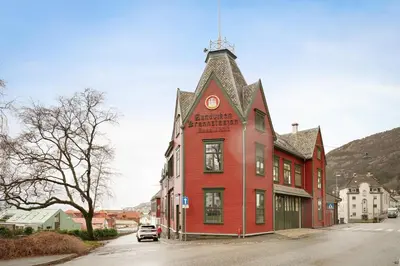 a red building with a clock tower on a street at Stilfull sentrumsnær leilighet in Bergen