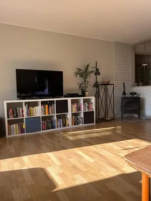 a living room with a tv and book shelves at 2 bed apartment in Trondheim